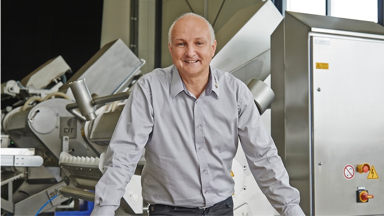 lächelnder Mann im Hemd  vor einer Maschine der Insort GmbH
