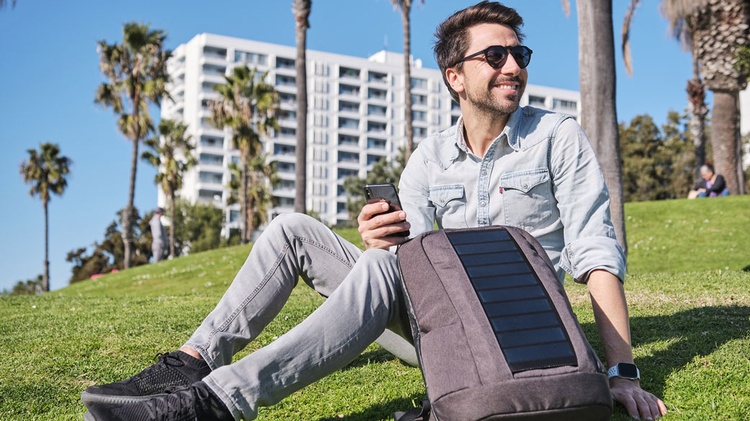 SUNNYBAG GmbH Gründer Stefan Ponsold sitzt mit seinem Rucksack auf einer sonnigen Wiese.