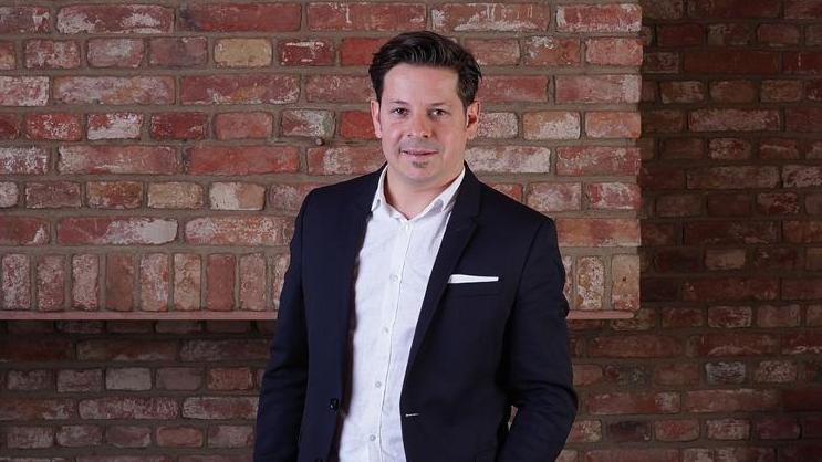 © UNiQUARE Software Development GmbH Portrait von Geschäftsführer Michael Schwarzenbacher vor einer Backsteinmauer